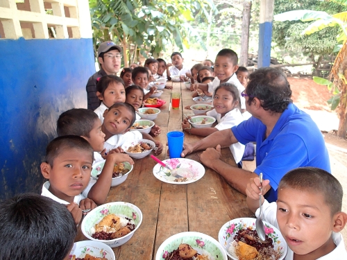 村の学校で子供と給食を食べる
